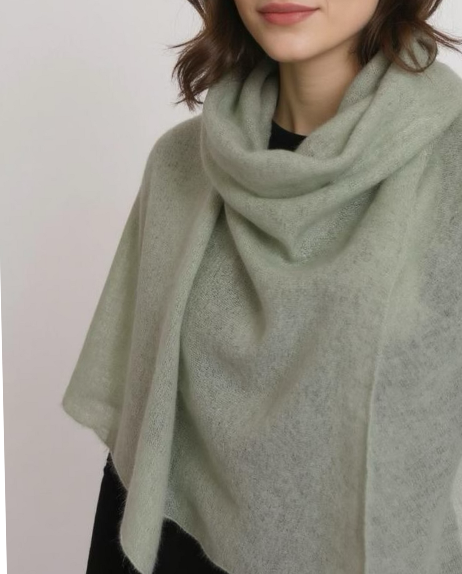 Woman wearing a light green scarf against a plain background