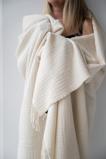 White Coccoon blanket wrapped around a woman