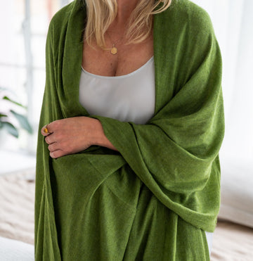Cashmere wrap in green wrapped around a blonde woman 